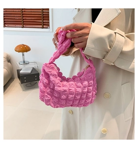 Détail du sac à main rose vif avec texture pop-corn et design en tissu plissé chic