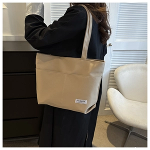Dettaglio della borsa tote minimalista in pelle beige con etichetta Fashion Instinct e tracolla