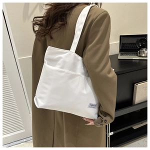 Dettaglio di una borsa tote bianca minimalista con etichetta tessuta Fashion Instinct