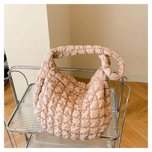 Detail of apricot quilted cloud bag featuring lightweight nylon fabric and pleated handle