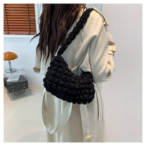 Sac hobo noir à texture bulles élégant porté avec un trench beige pour un look d'hiver