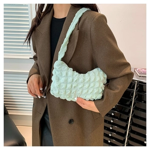 Sac à bandoulière vert clair à texture bulle porté avec un blazer marron pour un look chic