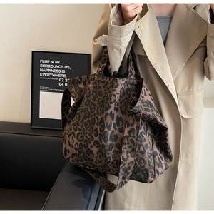 Detailed close-up of large leopard print canvas tote bag with dual strap functionality