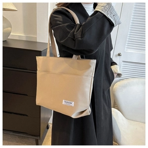 Borsa tote minimalista in tela beige con etichetta Fashion Instinct indossata da modella