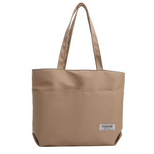 Elegante borsa tote in nylon kaki con tasche frontali ed etichetta moda su sfondo bianco
