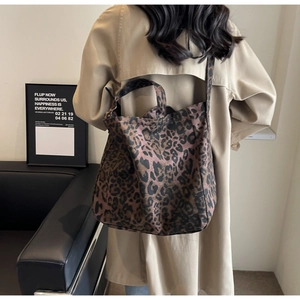 Detail of leopard print canvas tote bag styled with a long coat for an urban fashion look