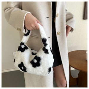 Dettaglio della borsa in peluche con motivi floreali neri e manico morbido al tatto