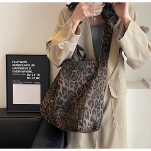 Detail of leopard print tote bag featuring a wide canvas shoulder strap and fabric texture