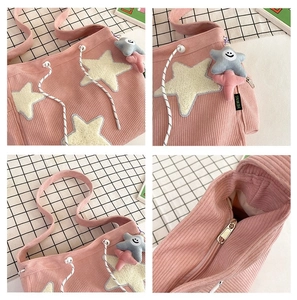Detailweergave van roze corduroy draagtas met pluche sterrenpatch en sterhanger