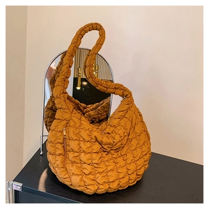 Close-up of caramel quilted nylon cloud bag with soft puffy texture and sleek finish