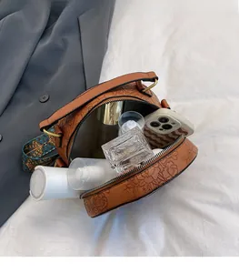 Detail of the brown embossed leather round bag showing spacious interior with double zippers