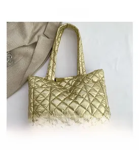 Macro view of gold quilted tote bag with metallic PU finish and diamond stitch patterns