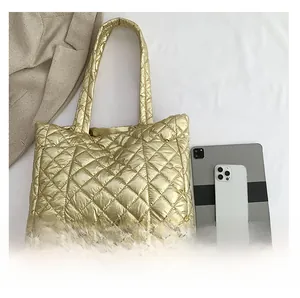 Flat lay of gold quilted tote bag showing large capacity with phone and tablet
