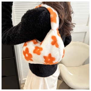 Dettaglio della borsa invernale in peluche con motivo floreale arancione su tessuto bianco