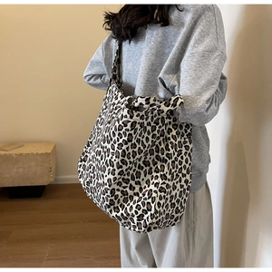 Leopard print canvas tote bag shown on model highlighting its large size and stylish drape