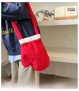 Dettaglio della borsa a tracolla in peluche rosso a forma di muffola con bordo bianco