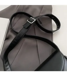 Close-up of black PU leather shoulder strap and adjustable silver square metal buckle
