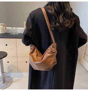 Vista posteriore di una modella che indossa un'elegante borsa sottobraccio in pelle marrone