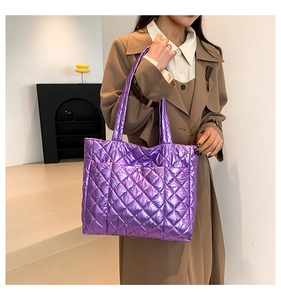 Metallic purple quilted tote bag shown on model wearing a chic khaki coat