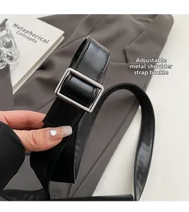 Detail of adjustable black leather strap with a polished silver square metal buckle