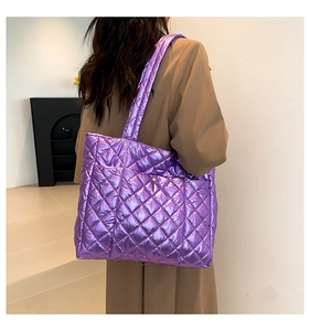 Rear view of a model wearing the purple metallic quilted tote bag with diamond stitching