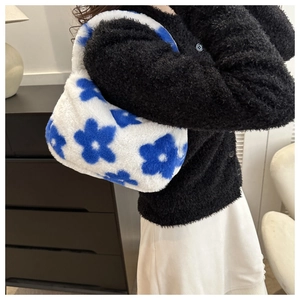 Dettaglio della borsa in peluche blu e bianca con motivo floreale in interni
