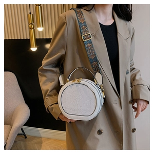 Detailed macro view of white PU leather bag with 3D floral relief and wide knit strap