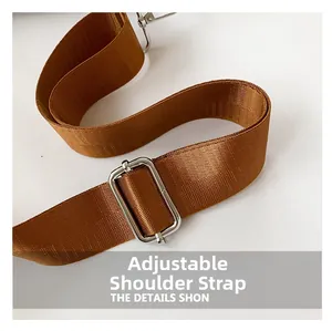 Close-up of adjustable brown nylon shoulder strap with premium silver metal buckle detail