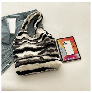Detail shot of zebra print plush tote bag showing spacious interior with an iPad and phone