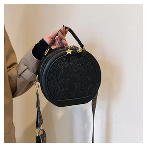 Minimalist black PU leather round handbag with floral embossing and star zipper