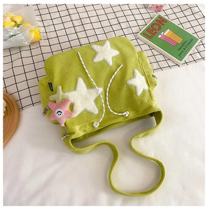 Detailweergave van de lichtgroene corduroy draagtas met pluche ster-patches en bedels