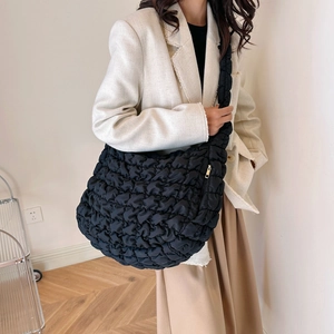 Quilted black cloud bag with bubble texture and comfortable wide strap for casual commuting