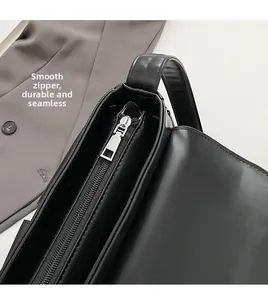Detailed macro view of the premium smooth silver metal zipper on a black PU leather bag