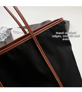 Detail of high-density black nylon tote with brown leather trim and fine hand-stitched edges