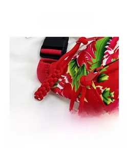 Close-up of durable nylon zipper and red woven tassels on floral print shoulder bag
