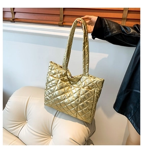 Detail of gold quilted puffer tote bag with metallic finish and wide shoulder straps
