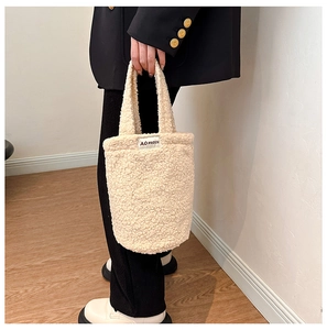 Close-up of fluffy off-white plush handbag texture with AO HUDIE fabric label detail