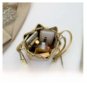 Macro view of golden bucket bag showing spacious interior with cosmetics and essentials