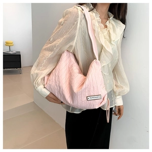 Pink pleated fabric hobo shoulder bag with a minimalist urban street style design