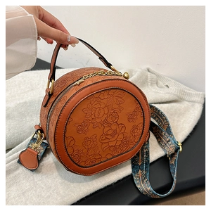 Retro brown PU leather round crossbody bag with floral embossing and colorful wide strap