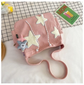 Detailopname van roze corduroy tote bag met sterpatches en pluche ster hanger