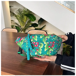 Detail view of floral nylon crossbody bag with woven zipper pull and plastic buckle