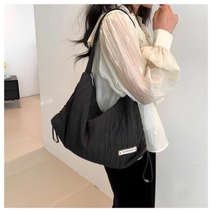 Fashionable black pleated shoulder bag with SUPERIOR label and drawstring detail