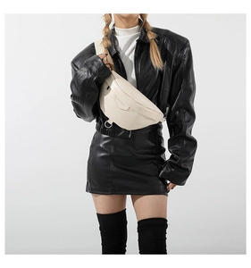 Close-up of beige glossy PU leather chest bag with zipper and metallic D-ring details