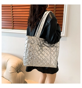 Silver quilted tote bag in metallic PU leather shown on model for daily lifestyle use