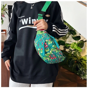 Detail of green floral nylon crossbody bag with wide strap and sturdy buckle closure