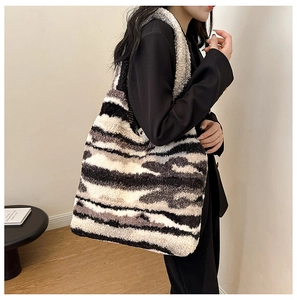 Detail of plush faux fur tote bag with black and white zebra pattern on shoulder