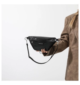 Close-up of black PU leather waist bag with silver metal rings and logo detail