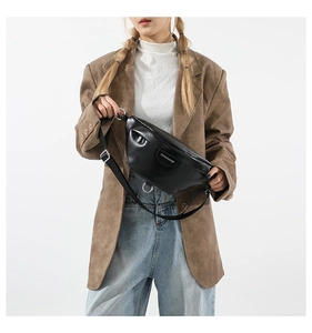 Close-up of black PU leather crossbody bag with silver metal hardware and adjustable strap