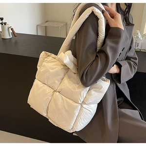 Detail view of white quilted down tote bag fabric texture with large capacity design